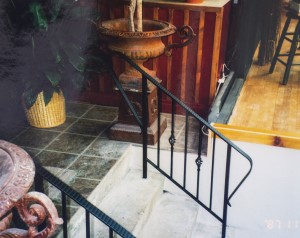 short decorative metal railing along each side of a short staircase on a porch